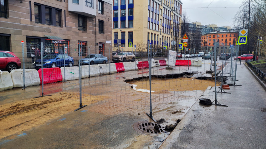 Зона дорожных работ с ограждениями и повреждённым асфальтом