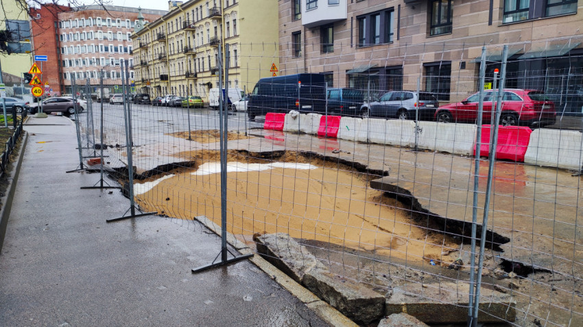 Огороженный провал асфальта вдоль тротуара на городской улице