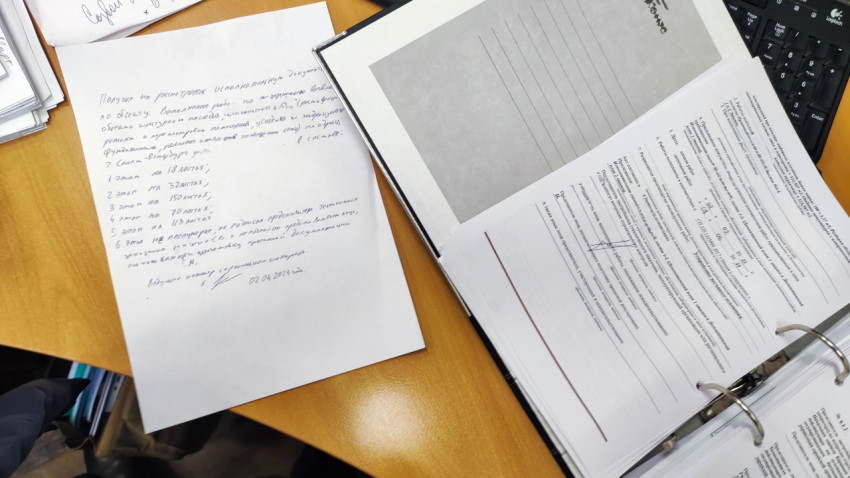 Рабочий стол с рукописной запиской и папкой с документами