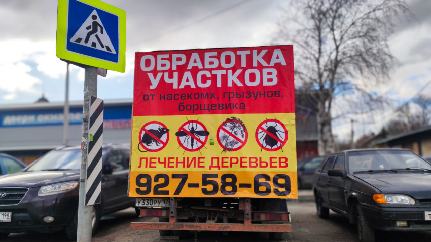 Рекламный щит о санитарной обработке участков рядом с парковкой