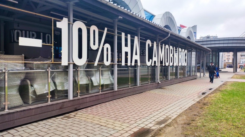 Витрина магазина с рекламой скидки на самовывоз в городском торговом комплексе