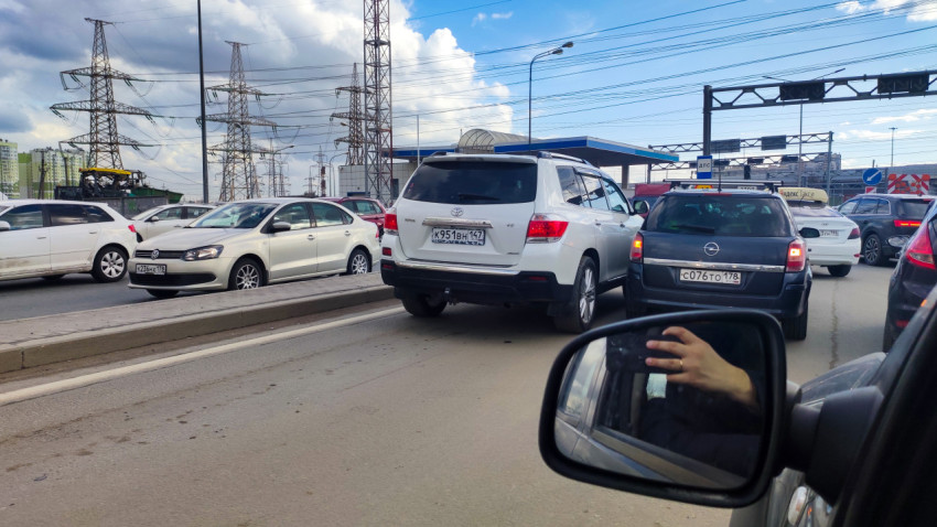 Плотное движение автомобилей на магистрали у промышленной зоны