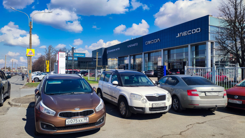 Парковка перед автосалонами вдоль городской дороги