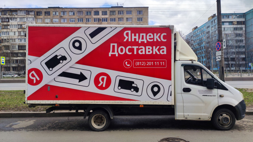 Грузовой автомобиль «Яндекс Доставка» на фоне жилых домов