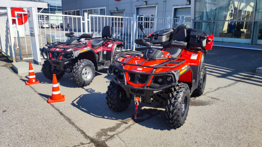 Два квадроцикла у входа в дилерский центр