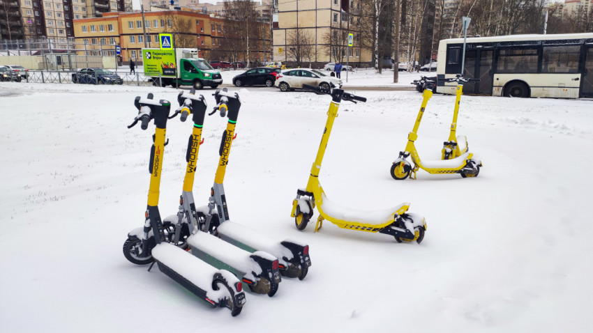 Группы арендуемых электросамокатов на заснеженной улице города