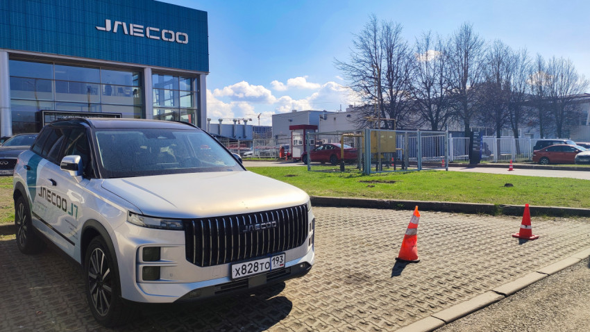 Jaecoo J7 на фоне здания дилерского центра и проезжей части