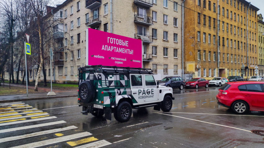 Автомобиль с рекламной конструкцией на улице жилого квартала