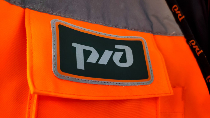 Эмблема РЖД на сигнальном жилете железнодорожного персонала