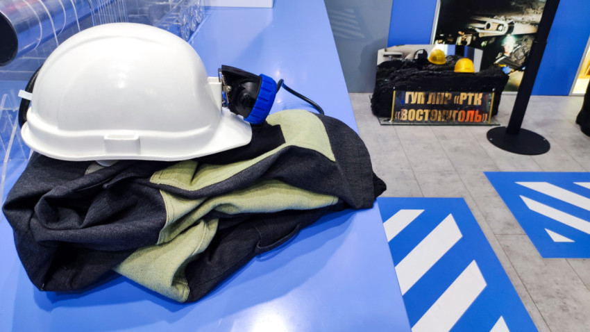 Белая защитная каска и спецодежда на выставочном стенде ЛНР