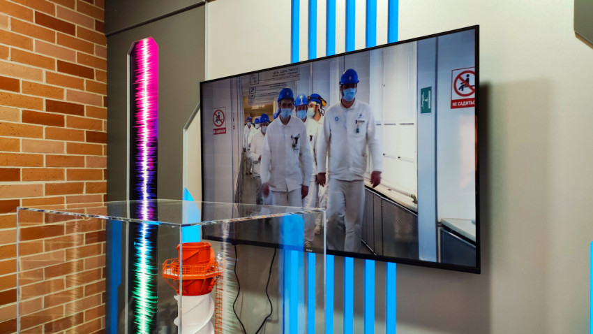 Экран с производственным видео и макет промышленного оборудования