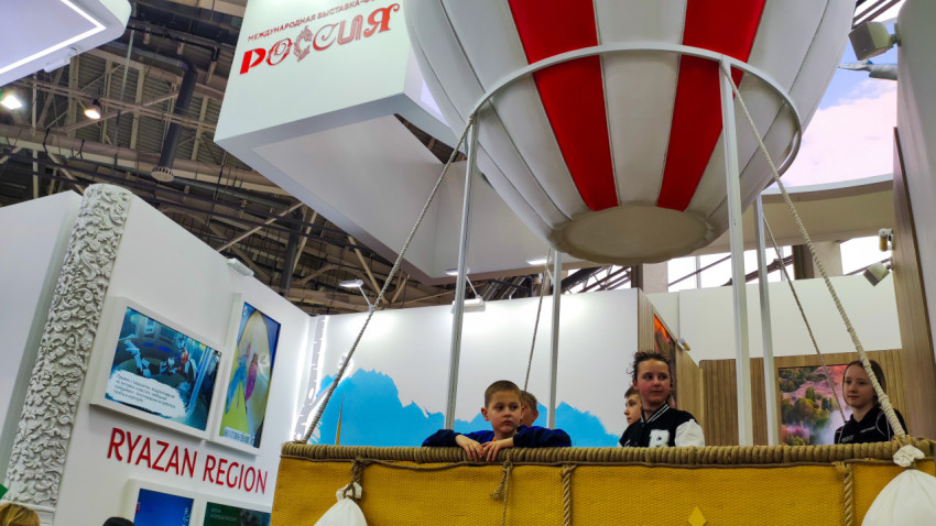 Дети в корзине макета воздушного шара на стенде региона