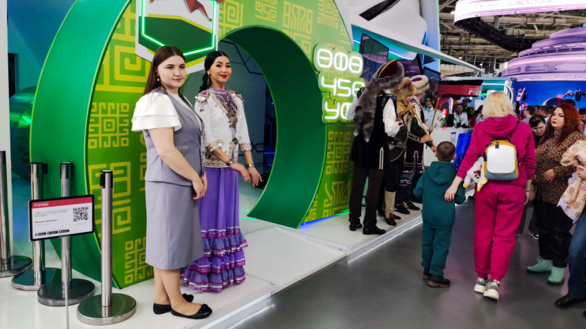 Посетители у стенда с национальными костюмами в павильоне №75 ВДНХ