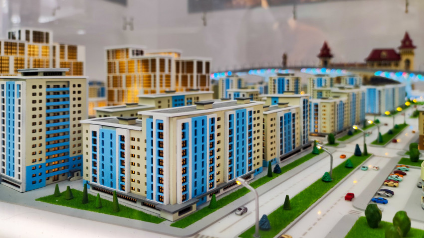 Макет жилых кварталов с голубыми фасадами и городской инфраструктурой