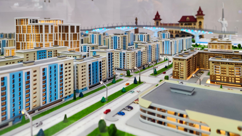 Макет жилых кварталов с высотной застройкой и мостом на заднем плане