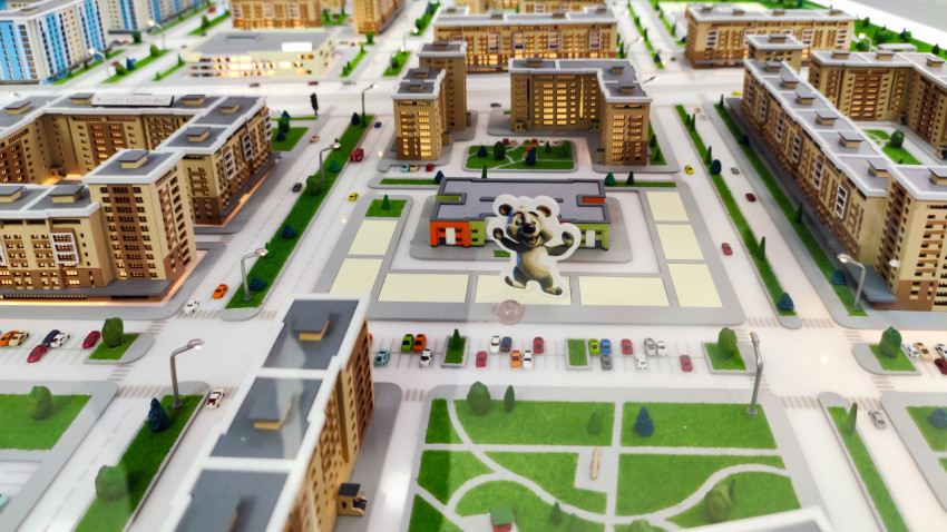 Макет жилого квартала с площадью и фигурой талисмана
