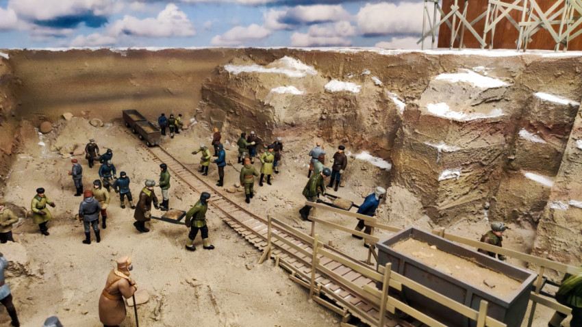 Диорама строительных работ в карьере с рабочими и рельсовой линией