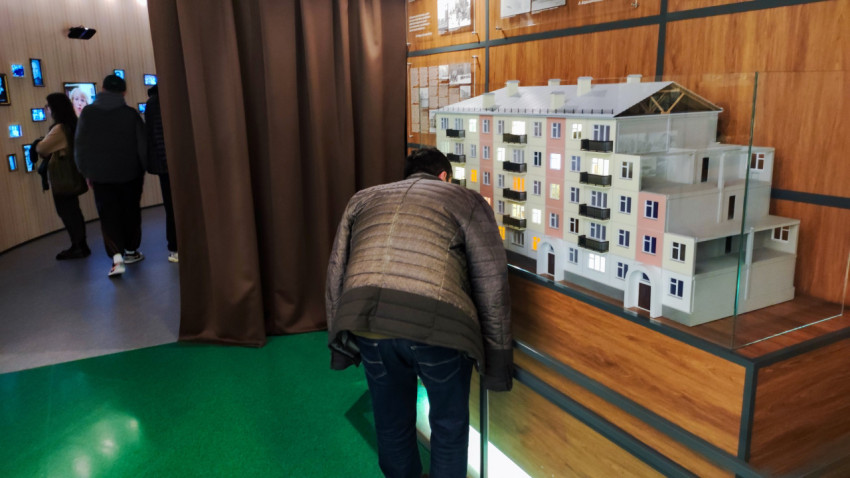 Посетитель рассматривает макет жилого дома в павильоне «АТОМ» ВДНХ