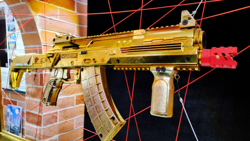 Золотистый макет штурмовой винтовки на декоративной экспозиции