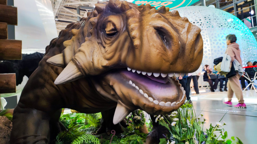 Модель парейазавра среди посетителей выставки в павильоне №75