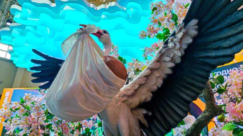 Скульптурная композиция аиста с младенцем на стенде Ставрополья на выставке в павильоне №75 ВДНХ