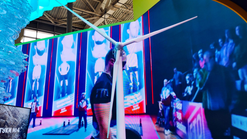 Макет ветрогенератора на фоне мультимедийного экрана на выставке в павильоне №75 ВДНХ