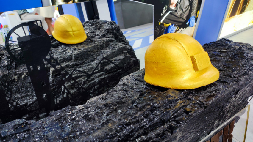 Жёлтая шахтёрская каска на угольном образце в экспозиции ЛНР