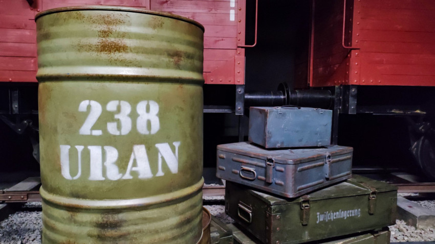 Бочка с маркировкой «238 URAN» перед вагонами исторической инсталляции