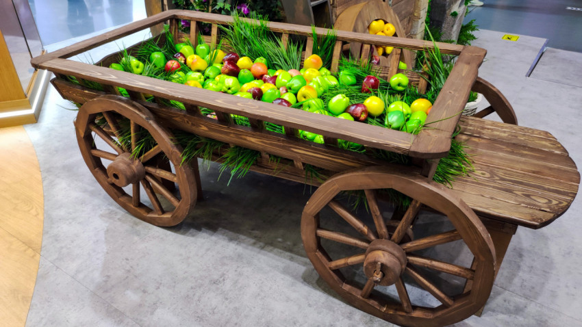 Деревянная повозка с декоративными яблоками крупным планом