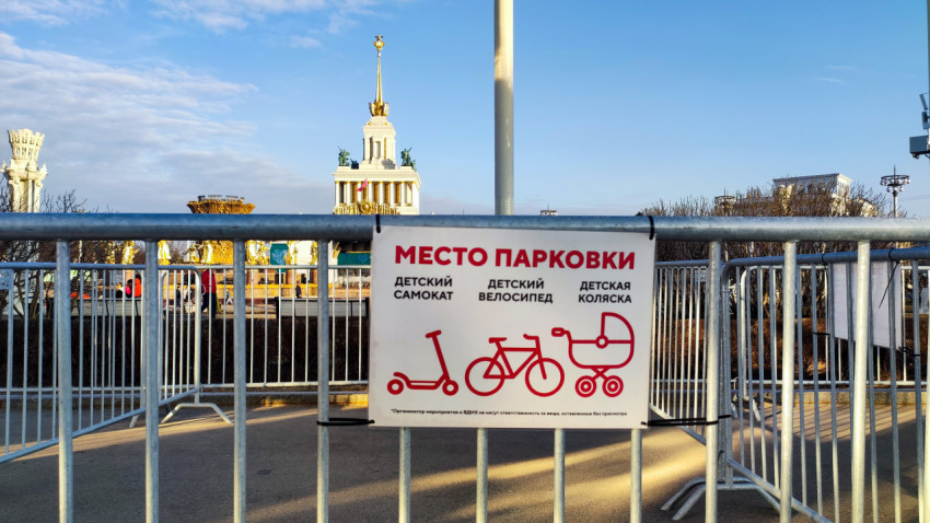 Табличка парковки детского транспорта на фоне центрального павильона ВДНХ