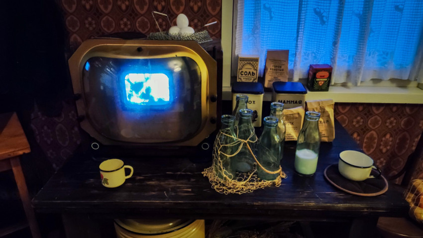 Ретро-телевизор и предметы быта на столе в стилизованной комнате СССР