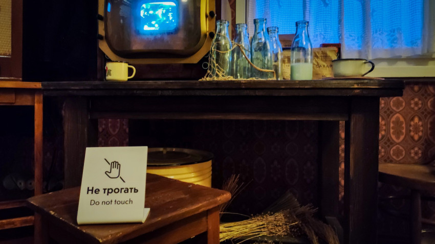 Детальный вид на стол с бутылками и ретротелевизором в павильоне «АТОМ»