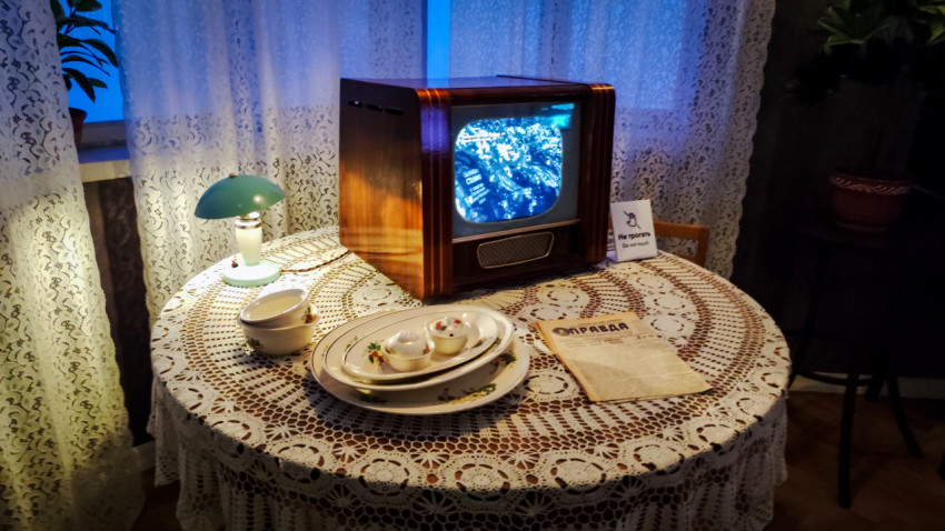 Телевизор «Рекорд» и сервировка стола в стилизованной комнате
