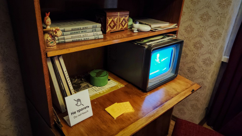 Ретро-телевизор и полка с советскими изданиями и декоративными предметами