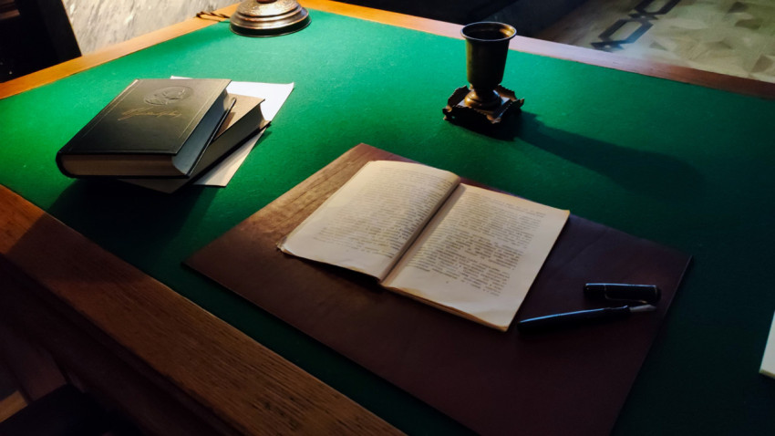 Рабочий стол с книгами и открытым документом в исторической зоне павильона «Атом»