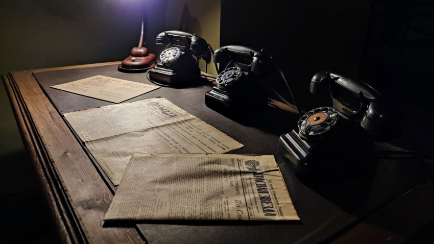 Архивные газеты и ретро-телефоны на столе павильона «АТОМ»