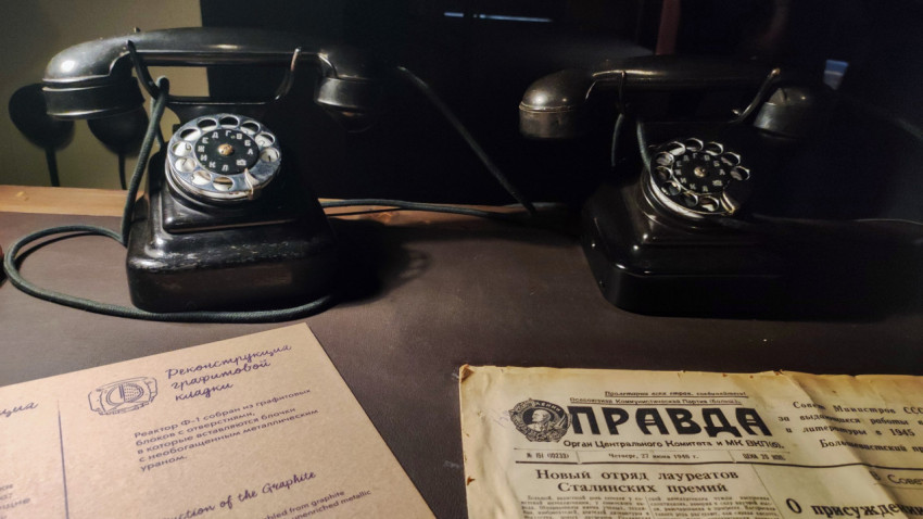 Настольные телефоны и газета «Правда» в исторической зоне павильона «АТОМ»