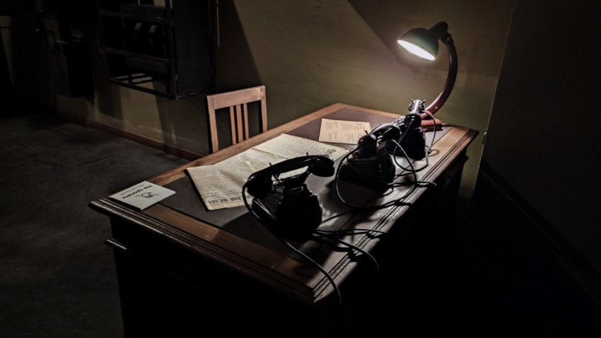 Рабочий стол с ретротелефонами и настольной лампой в экспозиции павильона «АТОМ»