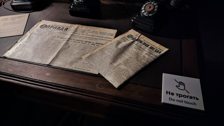 Старые газеты и телефоны на экспозиционном столе павильона «АТОМ»