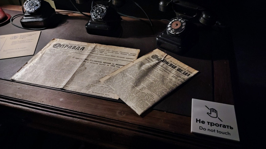 Экспозиционный стол с советскими газетами и ретро-телефонами в павильоне «АТОМ»