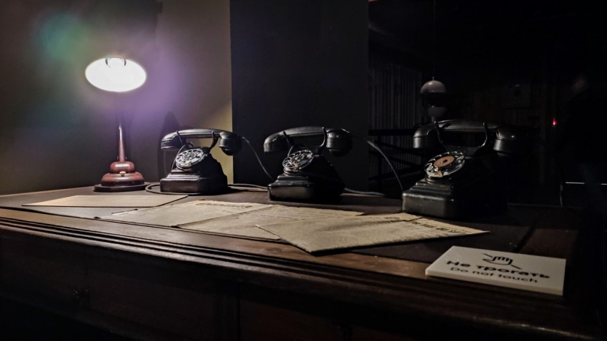 Ряд ретро-телефонов и исторические материалы на столе павильона «АТОМ»