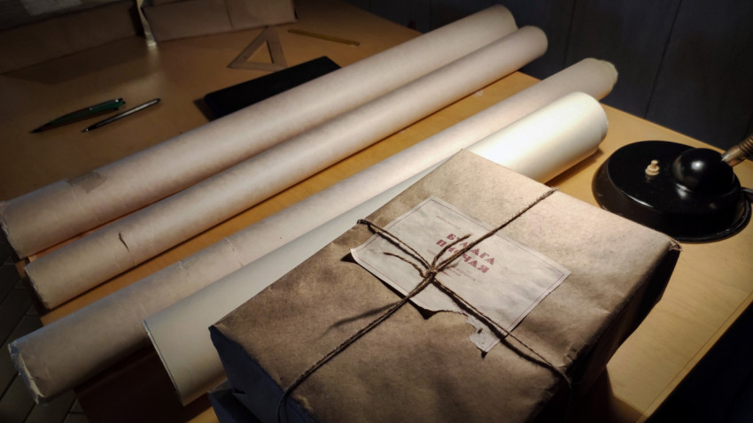 Рабочий стол с пакетом чертёжной бумаги и инженерными материалами в павильоне «Атом»