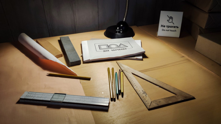 Рабочее место инженера с инструментами и тетрадями для черчения