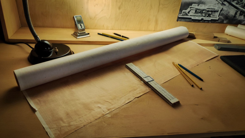 Инструменты инженера и чертёжные материалы на рабочем столе экспозиции