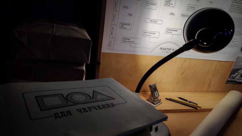 Папка «Для черчения» и настольная лампа на фоне схем павильона «АТОМ»