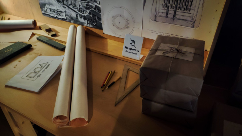 Чертёжные принадлежности и рулоны бумаги возле схем в павильоне «АТОМ»