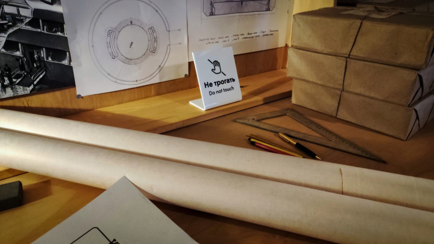 Рулоны чертёжной бумаги и инженерные инструменты на фоне технических схем