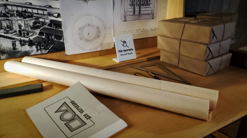 Рабочий стол с рулонами бумаги и папкой «Для черчения» в павильоне «АТОМ»