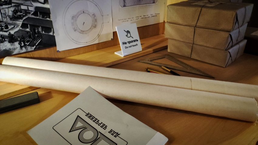 Рулоны бумаги и папка для черчения на рабочем столе экспозиции павильона «АТОМ»