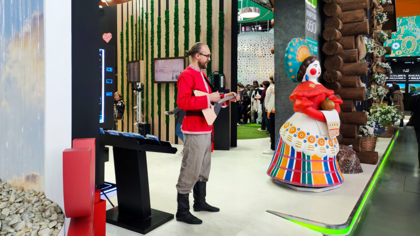 Музыкант в народном костюме у стенда региона на выставке «Россия»